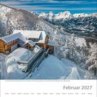 Februar 2027. Schnee bedeckt ein Holzhaus in den Bergen. Im Hintergrund verschneite Gipfel und blauer Himmel.