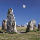 Keine Texte vorhanden. Steinkreise auf Wiese unter blauem Himmel mit Vollmond.