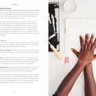 HANDABDRÜCKE ERSTELLEN. Zwei Hände liegen flach auf einem weißen Blatt, neben einer Farbrolle und Tinte.