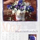 März, Hyazinthenduft. Text über die Herkunft und Farben der Hyazinthe. Bild zeigt einen Blumenstrauß mit lila und weißen Blumen.
