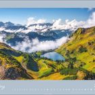 Text „März 2027“. Berglandschaft mit grünem Tal, See und weißen Wolken.