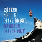 „Zögern füttert deine Angst. Handeln deinen Mut.“ Eine Person springt mutig von einem Felsen in den Himmel.