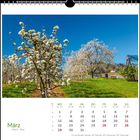 Kalenderseite für März mit blühendem Obstgarten und blauem Himmel darüber. Feiertage markiert.