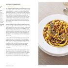 "Pasta with Sardines" Rezept neben einem Teller mit Pasta, Sardinen und Nüssen. Beige Tischdecke im Hintergrund.