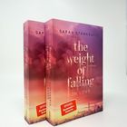 Zwei Bücher mit rosa Himmel und Stadt unten. Titel: "the weight of falling in love". Autorin: Sarah Stankewitz.