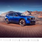 Kalender mit blauem BMW SUV vor Berglandschaft, Monat: Februar, Tage von Mo bis So aufgelistet.