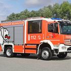 Feuerwehr Neuhausen steht groß geschrieben. Ein rotes Feuerwehrauto mit einem weißen Löwenlogo auf der Seite.