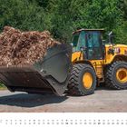 Text: "März", Wochentage "Mo" bis "So", Zahlen 1-31. Gelber Radlader transportiert Holzschnitzel, im Hintergrund Bäume.