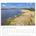 03 | 2027 RÜGEN Meine Insel. Eine Küstenlandschaft mit Schilf, einigen Booten und blauem Himmel mit Wolken.