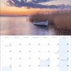 Kalender für März 2027, Usedom. Bild von einem Boot im Wasser bei Sonnenuntergang, umgeben von Schilf.