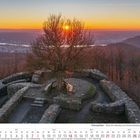 Kalender: "Siebengebirge - Ruine der Löwenburg bei Sonnenuntergang". März 2027. Ein Baum in einer Burgruine bei Sonnenuntergang.