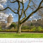 Kalenderseite März 2027. Historisches Mauerwerk und Turm, umgeben von grüner Wiese und blattlosen Bäumen.