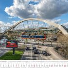 "Wuppertaler Schwebebahn" und "Schwebodrom" sind Schilder; Kalender zeigt März 2027. Eine Bahn hängt an einer Brücke.