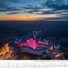 Schloss Burg und Burg an der Wupper, märchenhaft beleuchtet in Rosa; darunter ein Kalender für März 2027 mit markierten Feiertagen.