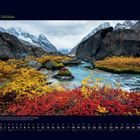 Monat Oktober in grün. Herbstlandschaft mit bunten Blättern, Bach und schneebedeckten Bergen im Hintergrund.