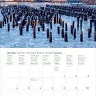 Kalender mit Januar-Tagen in sechs Sprachen. Stadtansicht mit Wolkenkratzern und Wasser mit Holzpfählen.