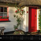 Text: Irland 03, Reetgedecktes Cottage bei Tully Cross, County Galway. Ein weißes Haus mit roter Tür und blühenden Rosen.