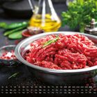 Kalenderdaten unten: Zahlen von 1 bis 31, daneben Mo bis So. Oben frisches Hackfleisch in einer Metallschüssel.