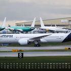 Lufthansa-Flugzeug auf Rollbahn; Kalender für März; Hintergrund mit anderen Flugzeugen und Hangar.