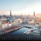 Text: "Jungfernstieg mit Rathaus" und "3". Kalenderansicht über einer Stadt mit Wasserfront und historischen Gebäuden.