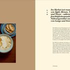 Überschrift: Im Herbst isst man Früchte wie Äpfel, Birnen, Trauben und Nüsse. Zwei Suppenteller mit Brotscheiben daneben.