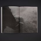 Keine Texte vorhanden. Schwarz-weißes Foto, dunkle und neblige Szene mit vager Figur und undefinierbarer Umgebung.