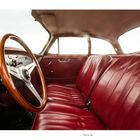 "Porsche 356" steht unter einer schicken Innenansicht mit rotem Ledersitz und Holzlenkrad.