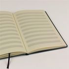 Seite 71, rechteckiges Notizbuch mit leeren Notenzeilen auf cremefarbenem Papier, schwarzes Lesezeichenband.