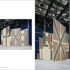 „Ai Weiwei | Eight-Nation Alliance Flags, 2006, Atrium Studios, Manchester.“ Große, farbige Flaggen hängen in einer Halle.