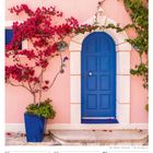 30. Woche 2027. JUL/AUG. 26 Mo, 27 Di, 28 Mi, 29 Do, 30 Fr, 31 Sa, 01 So. Eine blaue Tür in rosa Wand mit Bougainvillea.