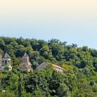 Text: WESTGEORGIEN. Sicht auf eine üppig bewaldete Hügellandschaft mit historischen Gebäuden.