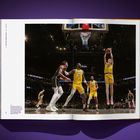 Austin Reaves (#15) im gelben Trikot springt zum Korb. Zwei Spieler in gelben Trikots, einer in schwarz-weiß auf einem Basketballfeld.
