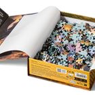 Geöffnetes Puzzle, Box mit Texten in mehreren Sprachen über Beth Gilbert, enthält viele bunte Puzzleteile.