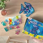 Auf der Verpackung steht "2 Puzzles Der Regenbogenfisch". Enthält bunte Puzzleteile eines Fisches und dekorative Elemente.