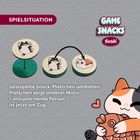 Spielsituation. Gestapelte Snack-Plättchen umdrehen; Plättchen zeigt anderes Motiv = entsprechende Person ist jetzt am Zug. Illustration: Katze hält Sushi.