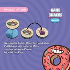 Spielbeschreibung mit illustrierten Snack-Plättchen und einem stilisierten Donut mit Gesicht. Enthält ein Logo und bunte Grafiken.
