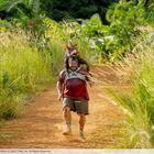 Doug aus "Sony Pictures' ANACONDA". Ein Mann rennt auf einem Feldweg, ein Wildschwein auf den Schultern tragend.