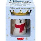 "Tasse mit Kronendeckel" steht auf einer Verpackung. Ein Bär mit rotem Schal ist auf der Tasse abgebildet.
