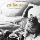 "Wo eine Katze wartet, dort ist man zu Hause." Graue Katze auf gestreifter Bettdecke, Tasse Kaffee auf Tablett.