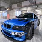 Kennzeichen: B 333 GRX. Blaues Auto mit schwarzen Details in einem Betonparkhaus. Sportliches Design.