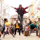 Text: "MOHLEN BROT", "KUNST STUBE", "DANCE CLUB". Eine Gruppe junger Tänzer in bunter Straßenkulisse.