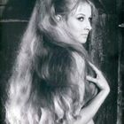 Kein Text erkennbar. Eine Frau mit langem Haar, einem Diadem, seitlich blickend, in einem schwarz-weißen Foto.