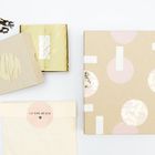 Der Text "ICH DENK AN DICH" steht auf einem Umschlag. Es sind beige und rosa Muster auf den Verpackungen.