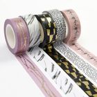 Verschiedene Washi-Tapes mit Mustern: goldene Linien, Federn, geometrische Formen und Blumen.