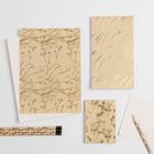 "Pro Design" auf Notizbüchern mit floralen Mustern. Beige Hefte und Bleistifte mit Pflanzenmotiven auf weißem Hintergrund.