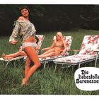 Text: "Die liebestollen Baronessen". Szene: Drei Frauen auf Liegestühlen in einem grünen Feld, eine tanzt im Vordergrund.