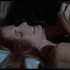 Es gibt keinen sichtbaren Text. Eine lächelnde Frau liegt auf einem Kissen, während jemand sie umarmt.