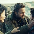 Ein Mann hält einen Jungen am Kopf, eine Frau schaut besorgt zu. Im Hintergrund eine steinige Landschaft.