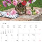 7·2027, Monatstage in sieben Sprachen. Bunte Blumen im Korb auf Steinmauer, darunter blau-weiß gestreifte Serviette.