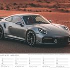 „August“ in vier Sprachen, darunter ein stylischer silberner Sportwagen auf einer Straße in der Wüste.